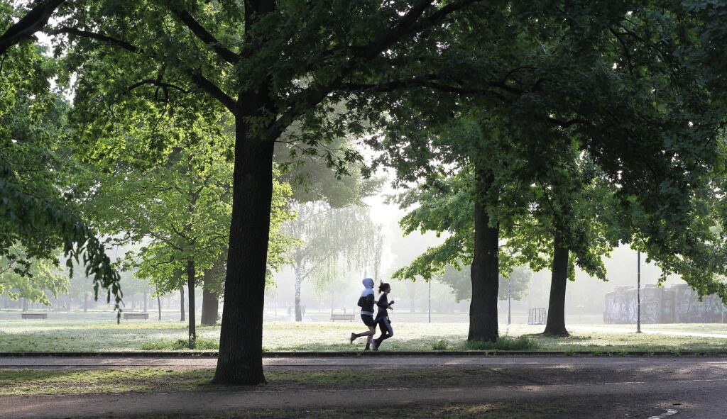 Personer som jogger gjennom en park